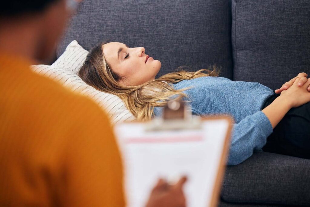 Woman in a calm, hypnotic state during a professional hypnotherapy session focused on subconscious healing.