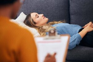 Woman in a calm, hypnotic state during a professional hypnotherapy session focused on subconscious healing.